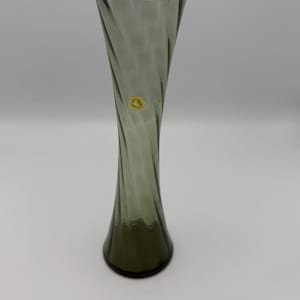 May include: A dark green glass vase with a twisted design. The vase is approximately 10 inches tall.