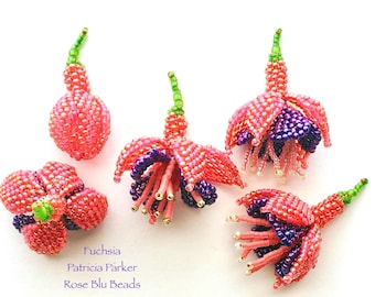 May include: Five handcrafted beaded fuchsia flower ornaments in shades of pink, purple, and green. Each piece features intricate seed bead work with a small green stem. The text "Fuchsia Patricia Parker Rose Blu Beads" is printed in purple.