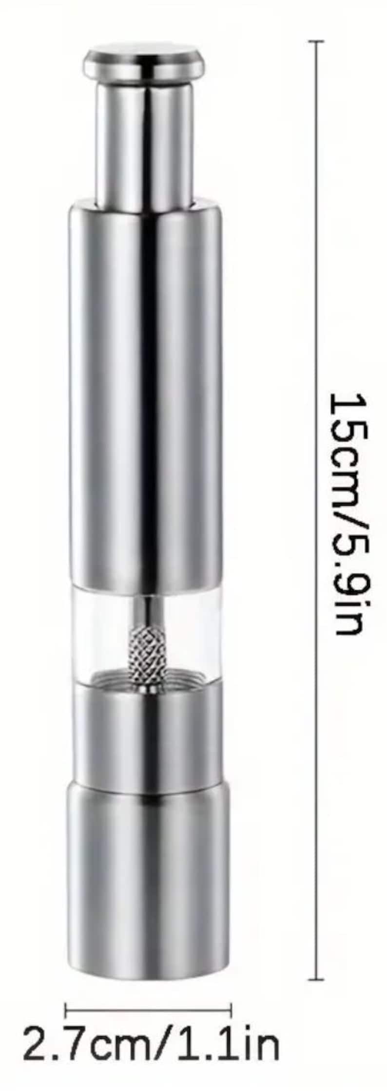 Pu&ograve; includere: Un macinapepe in acciaio inossidabile argentato con una sezione in vetro trasparente al centro. Il macinapepe &egrave; alto 15 cm e largo 2,7 cm.