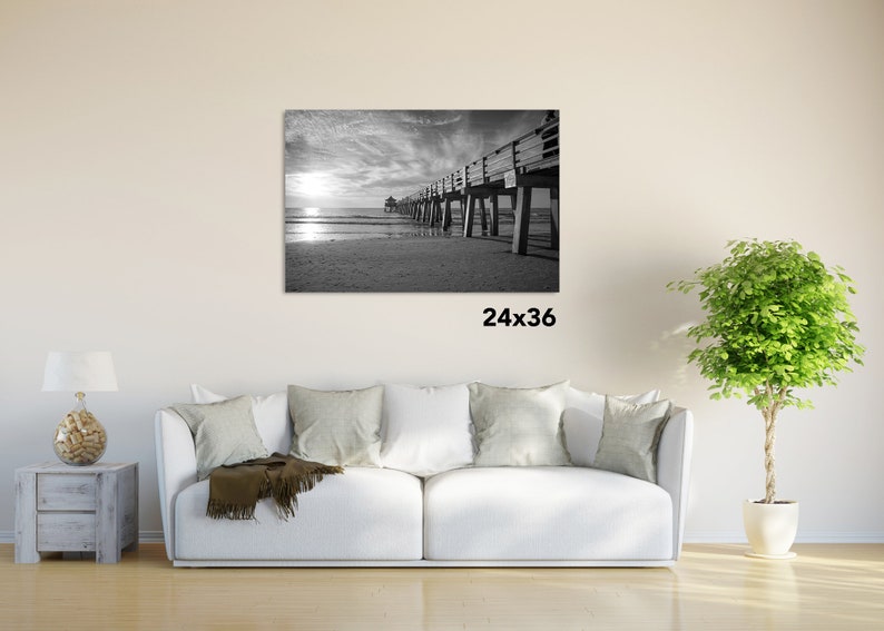 Puede incluir: Fotograf&iacute;a en blanco y negro de un muelle de madera que se extiende hacia el oc&eacute;ano. El muelle tiene una barandilla y est&aacute; sostenido por pilotes de madera. El cielo est&aacute; nublado y el agua est&aacute; tranquila. La imagen mide 61 cm por 91 cm.