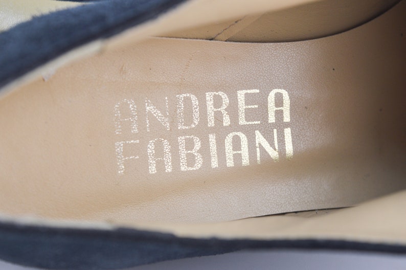 Peut inclure: Gros plan de l'int&eacute;rieur d'une chaussure en daim noir avec le nom de la marque "ANDREA FABIANI" imprim&eacute; en lettres dor&eacute;es.