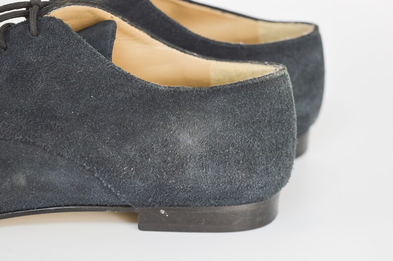 Peut inclure: Une paire de chaussures en daim bleu fonc&eacute; avec des lacets. Les chaussures ont une pointe arrondie et un talon bas.