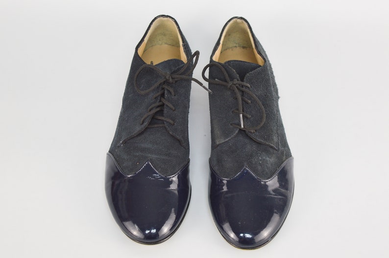Peut inclure: Une paire de chaussures &agrave; lacets en daim et cuir verni bleu marine.