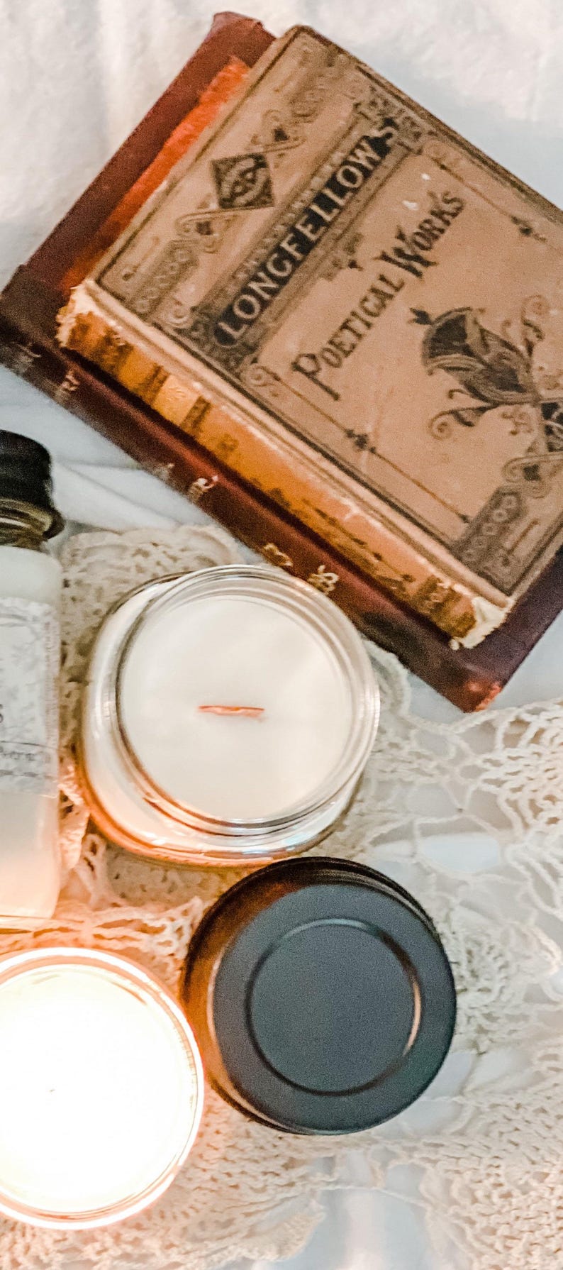 Old Books scented, Wooden Wick Soy Candle in a mason jar. The mysterious and cozy scent of old vintage books, libraries and dusty shelves full of leather bound wonders.  Crafted by Teresa Lynns Simple Luxuries in Monrovia, Indiana.  Pictured with a stack of antique books from her collection.