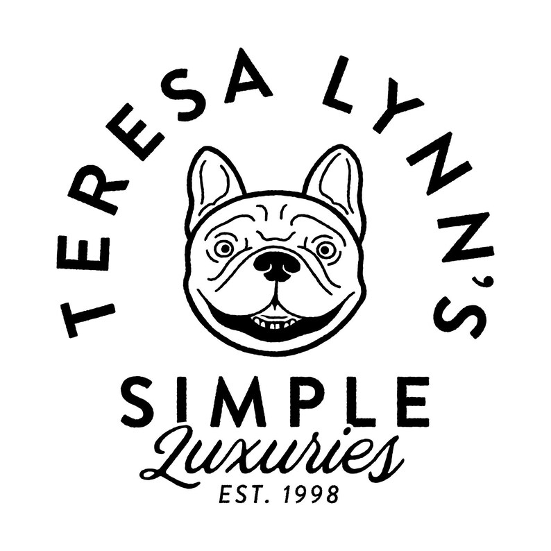 May include: Black and white logo featuring a smiling bulldog illustration. The text "TERESA LYNN'S" arches above the dog, with "SIMPLE Luxuries" below, and "EST. 1998" at the bottom. The design is clean and minimalist.