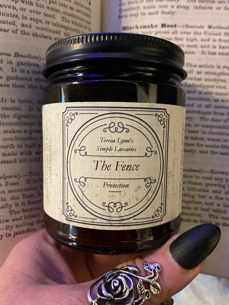The Fence, Protection and Boundary Setting Wooden Wick Soy Wax Candle in a dark Amber jar with a metal lid, held in Teresas Hand.Cedar and Redwood cleansing and protection blessings.
Cedar wood and Redwood essential oil, when used for charms are often referred to as “The fence” due to its powerful characteristic of forcing harmful projections out and keeping protective powers in. Crafted in Monrovia, Indiana at Teresa Lynns Simple Luxuries