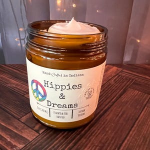 Hippies and Dreams lotion by Teresa Lynns Simple Luxuries.  Presented in 2 sizes of amber glass jars with a white linen label and a tie dyed peace sign on the label.