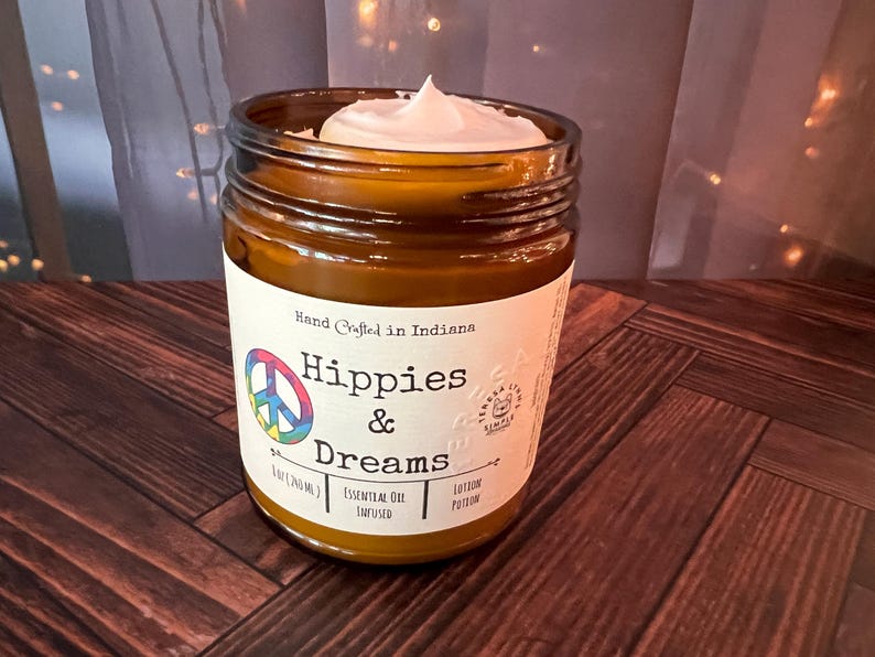 Hippies and Dreams lotion by Teresa Lynns Simple Luxuries.  Presented in 2 sizes of amber glass jars with a white linen label and a tie dyed peace sign on the label.