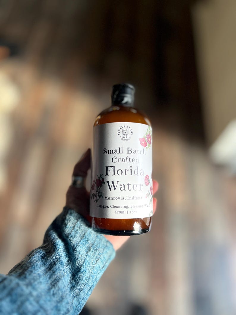 Pode incluir: Uma garrafa de vidro castanho de Teresa Lynn's Simple Scents Small Batch Crafted Florida Water. O r&oacute;tulo branco apresenta ilustra&ccedil;&otilde;es florais, o texto Monrovia, Indiana, e o volume 470ml | 16oz. Est&aacute; rotulado como Cologne, Cleansing, Blessing Water.