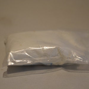 May include: A white powder in a clear plastic bag.
