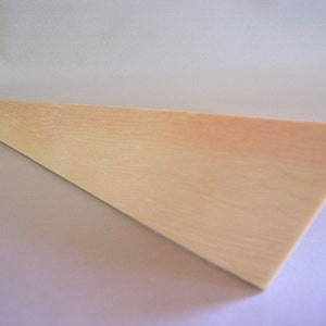 May include: A light wood triangle with a smooth surface and a slightly orange hue.
