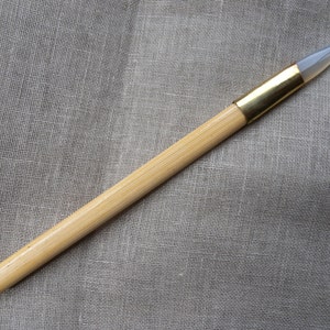 以下が含まれることがあります： 透明なガラスの先端と金色の金属バンドが付いた木製のツール。このツールは、クラフトやアートプロジェクトに使用されます。