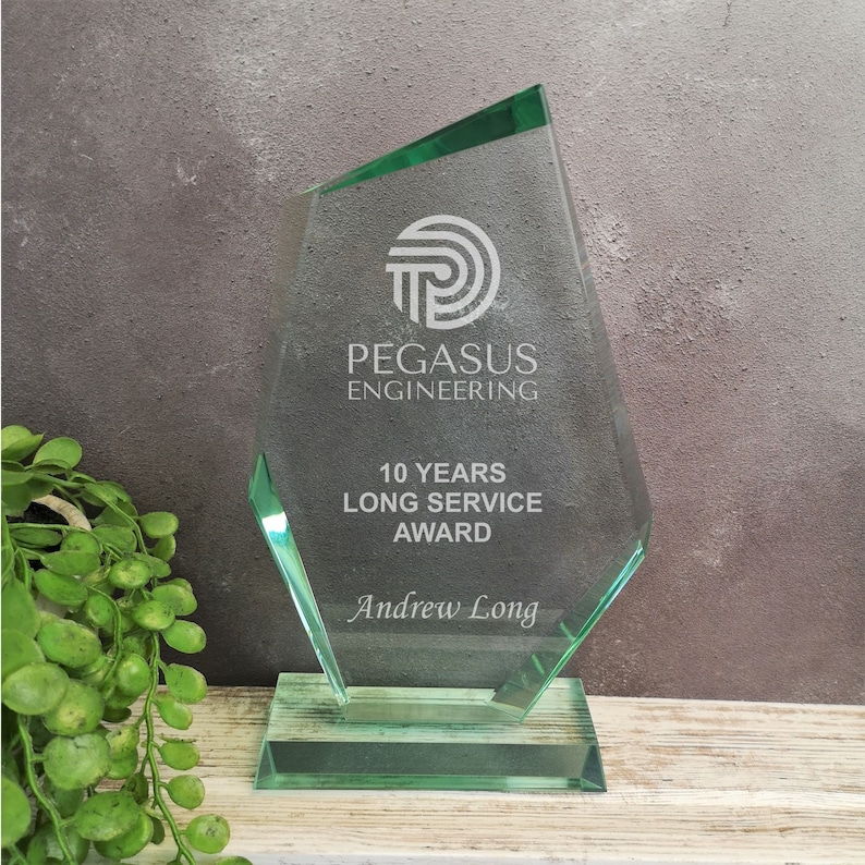 May include: A green glass award with a white logo that says "PEGASUS ENGINEERING" and the text "10 YEARS LONG SERVICE AWARD" and "Andrew Long".