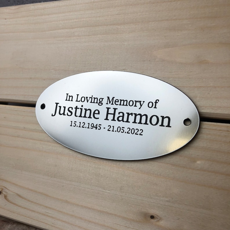 May include: Silver oval memorial plaque with the text "In Loving Memory of Justine Harmon 15.12.1945 - 21.05.2022"
