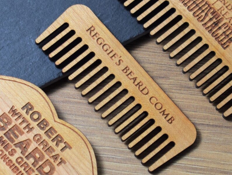 Peut inclure: Des peignes &agrave; barbe en bois avec texte grav&eacute;. L'un des peignes indique "Reggie's Beard Comb". Un autre indique "Robert with great beard". Les peignes sont brun clair avec des dents espac&eacute;es. Les peignes sont probablement destin&eacute;s au toilettage de la barbe.