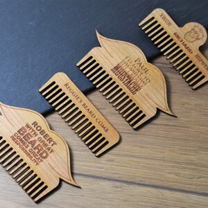 Peut inclure: Quatre peignes &agrave; barbe en bois avec texte grav&eacute;. L'un d'eux porte l'inscription "TRUE RICHARD HIPSTA" avec une petite illustration. Un autre dit "PAUL I'D LOVE TO STAY AND CHAT BUT I REALLY MOUSTACHE". Le troisi&egrave;me dit "REGGIE'S BEARD COMB". Le dernier dit "ROBERT WITH GREAT BEARD COMES GREAT RESPONSIBILITY".