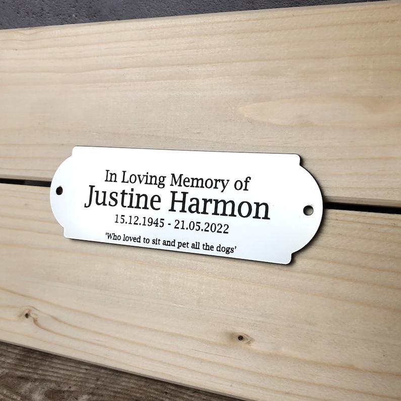 May include: Silver memorial plaque with the text "In Loving Memory of Justine Harmon 15.12.1945 - 21.05.2022 'Who loved to sit and pet all the dogs'"