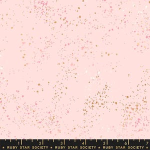 May include: Pink fabric with a speckled pattern of gold, pink, and white dots. The fabric has a soft, pastel color scheme and a subtle shimmer. The bottom of the image has the text "RUBY STAR SOCIETY".
