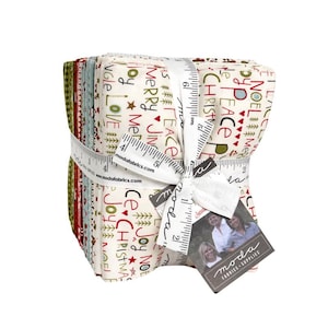 May include: A stack of folded fabric squares tied with a white measuring tape featuring the text Moda Fabrics. The fabric has a cream background with red and green text including Merry, Joy, Peace, Noel, and Christmas, along with small tree icons.