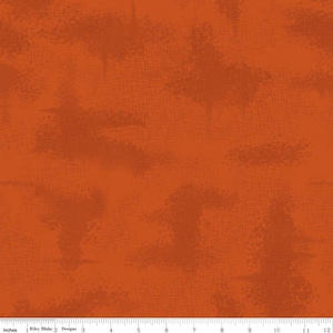 May include: Orange fabric with a textured, mottled design. The fabric has a grid-like pattern and darker orange blotches. The bottom of the image shows a ruler with inches.