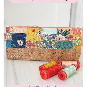 May include: A rectangular pencil pouch with a cork bottom and a patchwork top featuring floral patterns. The pouch is 5 inches high, 12 inches wide, and 2 inches deep. The text "Cork Bottom Pencil Pouch" is displayed at the top.