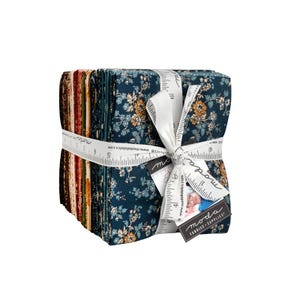 May include: A stack of folded fabric squares tied with a white ribbon printed with a ruler design. The fabric features floral patterns in shades of dark blue, orange, and brown. A tag attached to the ribbon displays the text Moda Fabrics Supplies.