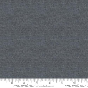 May include: A close-up of a dark gray fabric with a subtle texture. The fabric is measured with a ruler in inches.