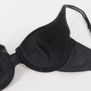 Op de afbeelding: Zwarte beha met beugel. De beha heeft een voorgevormd cupontwerp en verstelbare bandjes. De beha is gemaakt van een glad, effen zwart materiaal. Ontworpen voor comfort en ondersteuning.