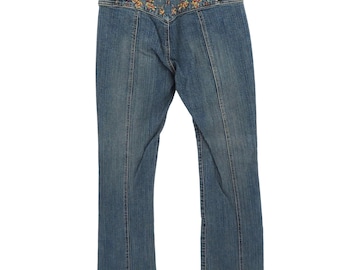 May include: Blue denim jeans with a high waist and a decorative embroidered design in shades of yellow, orange, and green across the waistband. The jeans have a straight leg cut and vertical seam details.