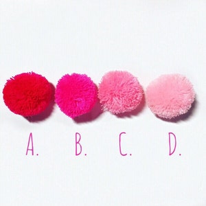 May include: Four pom-poms in different shades of pink, from red to light pink. The pom-poms are labeled A, B, C, and D.