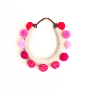 lucky yarn wrapped horseshoe with pink pom poms