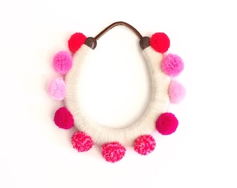 lucky yarn wrapped horseshoe with pink pom poms