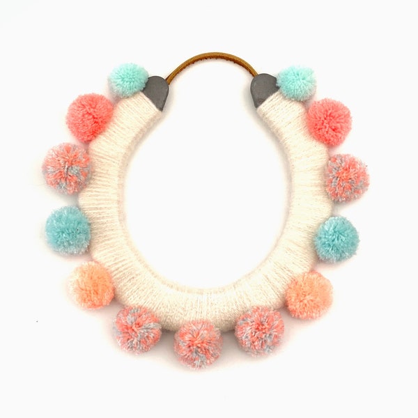 lucky yarn wrapped horseshoe with pastel pom poms