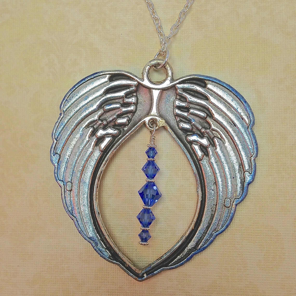 angel with wings holding blue amethyst pendant angel with wings holding blue amethyst pendant
