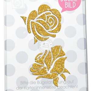 Könnte beinhalten: Ein goldfarbener Glitzer-Bügelbild mit zwei Rosen. Das Bügelbild ist auf einem weißen Hintergrund mit grauen Punkten. Der Text "BÜGEL-BILD" befindet sich in einer rosa Sprechblase. Der Text "Bitte die Bügelantung auf der Karteninnenseite beachten!" befindet sich am unteren Rand des Bildes. Der Text "Gedruckt auf 100% Altpapier. MIMMIS TRAKTOR®" befindet sich am unteren Rand des Bildes.