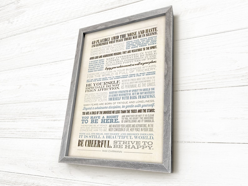 May include: A framed print with a white background and blue and black text. The text is a poem titled "Desiderata" by Max Ehrmann. The poem is about living a peaceful and fulfilling life.