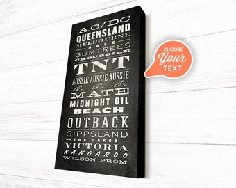 May include: Black and white typography print with Australian words and phrases, including "AC/DC", "Queensland", "Melbourne", "TNT", "Aussie Aussie Aussie", "Mate", "Midnight Oil", "Outback", "Gippsland", "Victoria", "Kangaroo", and "Wilson Prom".