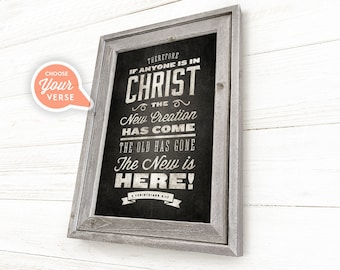 May include: A framed black and white print with a vintage design. The print features the text "THEREFORE IF ANYONE IS IN CHRIST THE NEW CREATION HAS COME THE OLD HAS GONE THE NEW IS HERE!" with the scripture reference "2 CORINTHIANS 5:17".