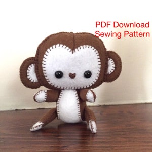 May include: A brown and white felt monkey toy with stitched details. The monkey has large black eyes and a small pink nose.  PDF Download Sewing Pattern.