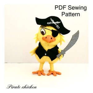 May include: A yellow felt pirate chicken doll wearing a black vest, eye patch, and pirate hat with crossed swords. It holds a silver felt sword. The text "PDF Sewing Pattern" and "Pirate chicken" are also visible.
