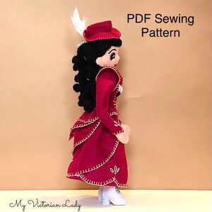 Könnte beinhalten: Handgefertigte Puppe in einem viktorianischen Kleid in Rot mit weißen Verzierungen, passendem Hut mit Feder und weißen Stiefeln. Die Puppe hat schwarzes Haar. Der Text "PDF Sewing Pattern" ist im Bild enthalten.