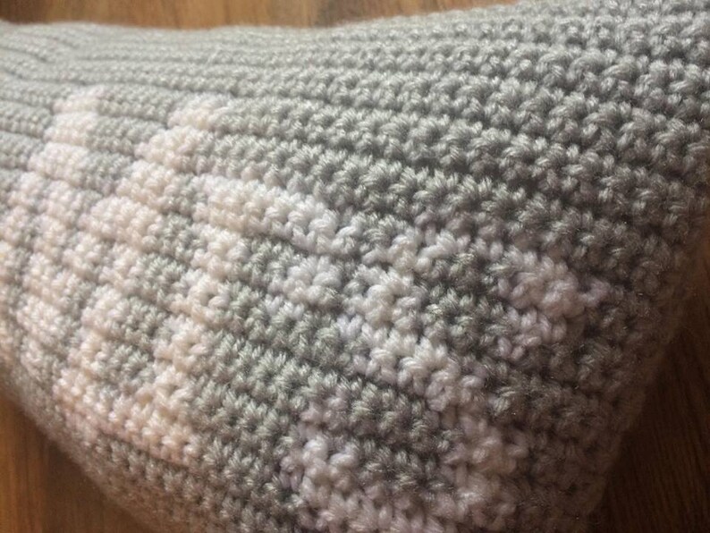 May include: A gray and white crocheted pillow with a geometric pattern.