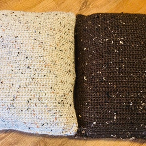 May include: Two crocheted throw pillows, one white with brown flecks and one brown with white flecks.