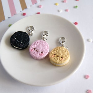 Op de afbeelding: Drie bedelarmen in de vorm van koekjes met schattige gezichtjes. De koekjes zijn zwart-wit, roze-wit en geel-wit.