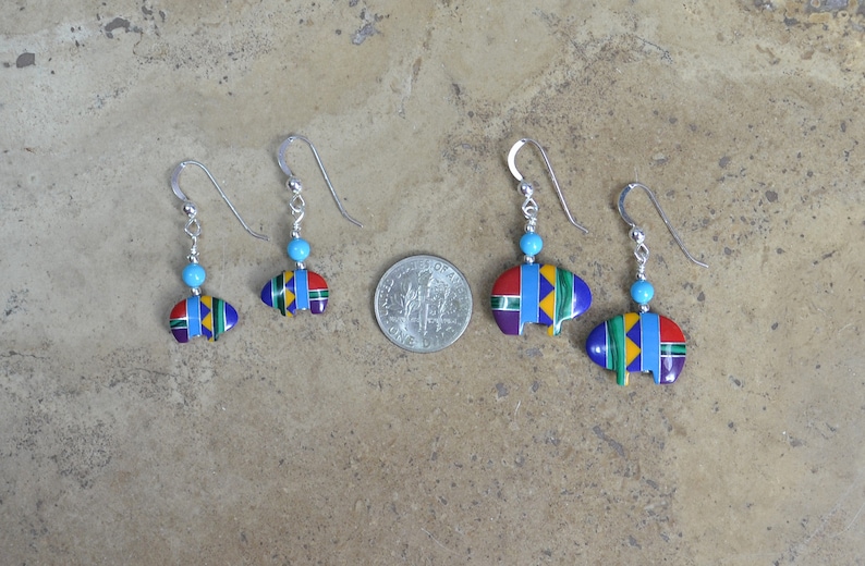 May include: Three pairs of sterling silver earrings with turquoise beads and a colorful bear paw design. The earrings are different sizes, with the largest pair being about the size of a US quarter.