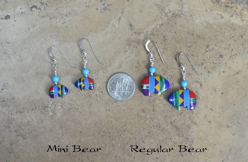 May include: Two pairs of sterling silver earrings with turquoise beads and bear-shaped pendants. The pendants are decorated with colorful geometric patterns. The earrings are labeled "Mini Bear" and "Regular Bear".