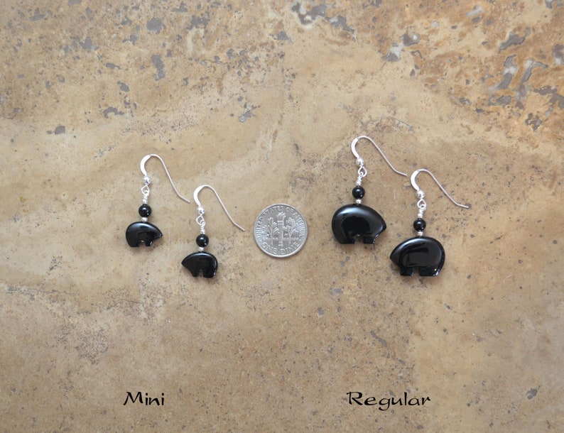 K&ouml;nnte beinhalten: Zwei Paar schwarze Onyx-B&auml;ren-Ohrringe, ein Paar ist kleiner als das andere. Das kleinere Paar ist mit "Mini" und das gr&ouml;&szlig;ere Paar mit "Regular" beschriftet.