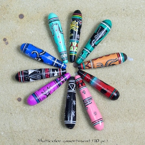 May include: A collection of ten hand-painted wooden beads in various colors, arranged in a circular pattern. Each bead features unique tribal-inspired designs in shades of blue, green, pink, black, and orange. The text at the bottom reads "Multicolor assortment (10 pc)."