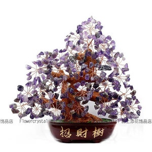 Puede incluir: Una escultura decorativa de árbol de cristal de amatista. El árbol presenta un tronco y ramas marrones, con racimos de piedras de amatista moradas. Se encuentra en una maceta marrón oscuro con caracteres chinos. También se ve la palabra "Flowercrystal".