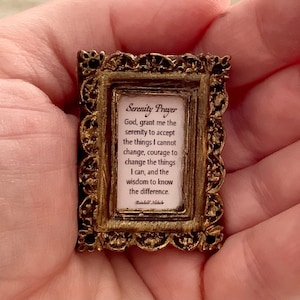May include: A small gold-colored framed picture with a white background and black text. The text reads "Serenity Prayer" and includes the following quote: "God, grant me the serenity to accept the things I cannot change, courage to change the things I can, and the wisdom to know the difference."